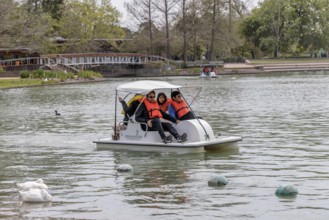 Young family piloting a pedal boat on Lake McGovern at Hermann Park in downtown Houston, Texas