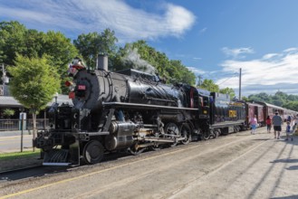 Passengers boarding the Great Smoky Mountains Railroad train pulled by steam engine 1702 on an