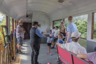 Young family watches a ticket collector punch their souvenir tickets on the Great Smoky Mountains