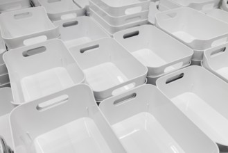 White plastic baskets neatly stacked in rows in the showroom section of the IKEA home store