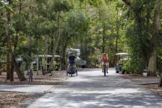 Man and woman ride bicycles through a camping loop at Fort Wilderness campground at Walt Disney