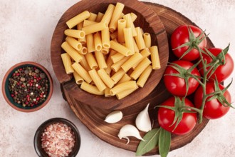 Pasta ingredients spread out, on a wooden surface, with tomatoes and spices, ready to cook, there