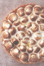 Lemon meringue cake, golden brown, toasted, on a light table, no people