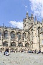 Busker musician performing in Bath Abbey church yard, city of Bath, north east Somerset, England,