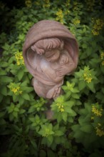 Terracotta statue, girl, between spotted loosestrife (Lysimachia punctata), also known as spotted
