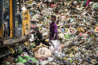 Garbage collectors searching for recyclable material at garbage disposal site, in Assam, India on