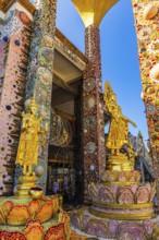Gilded Buddha statues standing on pedestals decorated with mosaics and glass works of art, Buddhist