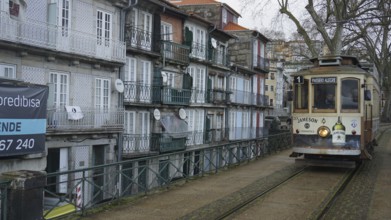 Historic tram runs along a street with old buildings, pilgrims on the Caminho Portugues, Portugal