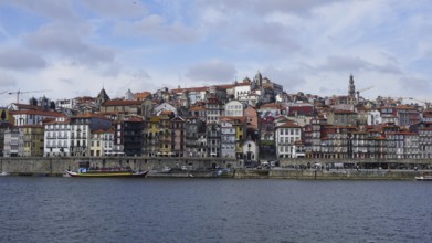 Panoramic view of the Douro in Porto with colorful buildings on the river under cloudy sky, Porto,