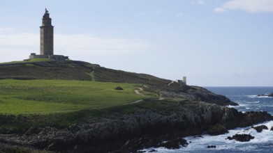 Lighthouse on a grassy cliff overlooking the sea, A Coruna, Spain