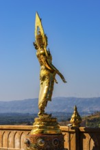 Standing gilded Buddha statue on a viewing terrace, Wat Phra That Sorn Kaew Buddhist temple