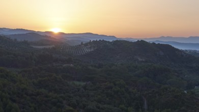 Wide landscape with hills at dusk, sunset behind the mountains, Hotel Europa, garden restaurant and