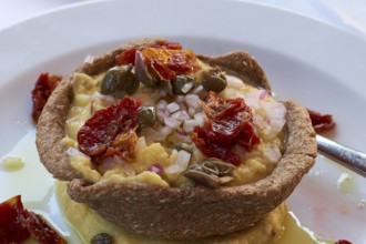 Mediterranean starter with fresh ingredients such as dried tomatoes and capers on a plate, Hotel