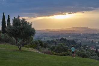 Person standing in the foreground, looking at a vast landscape in the evening light, Hotel Europa,