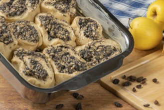 Dough pieces with poppy and apple filling in a baking pan ready for baking