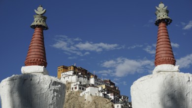 View through two stupas towards Thiksey monastery on a hill under blue sky, Indus Valley, trekking