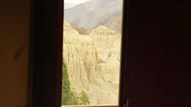 View from a dark window of a rocky, desert-like mountain landscape, trekking in Ladakh, Himalayas,