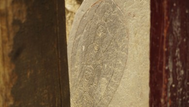 A stone slab with carved Buddha relief as a sacred work of art, trekking in Ladakh, Himalayas,