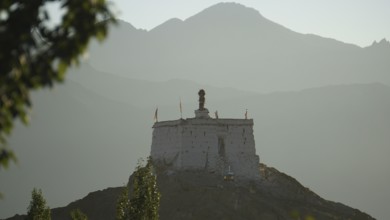 A secluded Buddhist sanctuary on a hill surrounded by mountains at dusk, Leh, trekking in Ladakh,