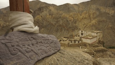 An engraved Mani stone in a mountainous landscape, near an ancient monastery, Leh, trekking in