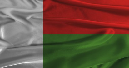 Flag of Madagascar with fabric textured background. Close up of National flag of Madagascar with