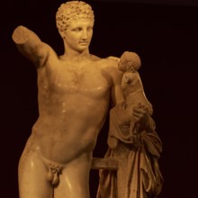 Statue of Hermes of Praxiteles, ancient marble statue of a man with a small child, partly damaged,