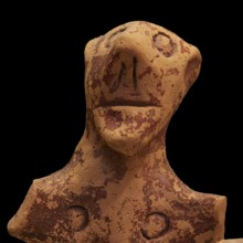 Anthropomorphic votive statuette, clay figure with abstract facial features and antique-looking