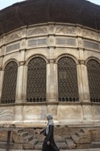 Cairo, Egypt. July 7th 2024 A local woman walks past one of the many restored monuments along