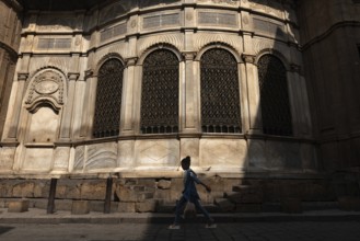 Cairo, Egypt. July 7th 2024 A young Egyptian girl walks past one of the many restored monuments