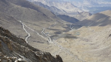 Serpentine road snakes through barren valleys and mountains, on the way to Nubra Valley, trekking