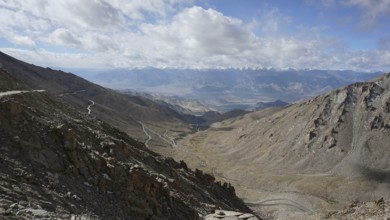 Barren mountain panorama with winding roads under a cloudy sky, trekking in Ladakh, Himalayas,