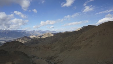 Rugged mountain landscape under a blue sky with scattered clouds, trekking in Ladakh, Himalayas,