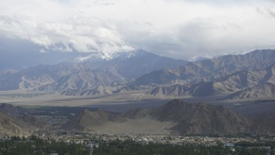 Wide mountain landscape with cloudy sky and distant snow-capped peaks, trekking in Ladakh,