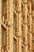 Yellow house, with a water-strewn brick façade and decorated with 52 moose shovels and hunting