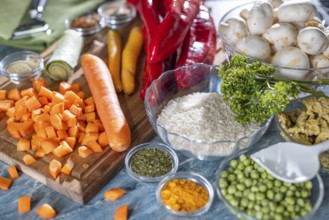 Fresh ingredients and spices such as peppers, peas, rice, mushrooms and sliced carrots
