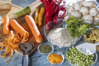 Fresh ingredients and spices such as peppers, peas, rice, mushrooms and peeled carrots