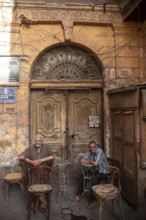 Cairo, Egypt. July 3rd 2024 Two old Egyptian men sit outside a café in Al-Darb Al-Ahmar district of