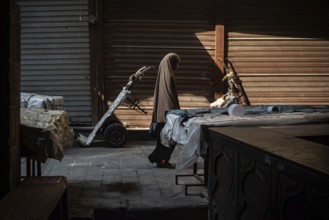 Cairo, Egypt. July 1st 2024 An Egyptian Muslim woman walks along the cobbled streets of a closed