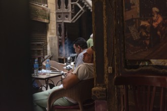 Cairo, Egypt. June 24th 2024 An Egyptian man sleeps in a Downtown Cairo coffee shop during the