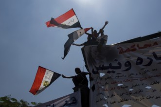 Cairo, Egypt. July 15th 2011 Anti government protestors with banners and flags silhouetted against