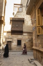Cairo, Egypt. December 7th 2022 People walk by traditional Arabic Islamic architecture Mashrabiya