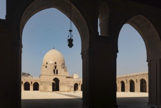 Silhouetted arches of the interior architecture and courtyard showing the dome of Ibn Tulin Mosque