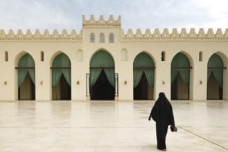 A Muslim women entering the prayer hall of historic Mosque of al-Hakim, also known as Al-Anwar,