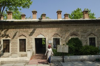 Bursa, Turkey. April 21st 2014 A Turkish Muslim woman walks from the exit of the Koza Han in the