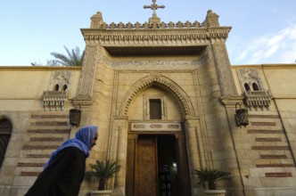 Cairo, Egypt. December 31st 2012 An Old Egyptian Copt walking past the entrance to the Hanging