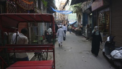 Quiet alley in a Muslim neighborhood of Delhi with isolated people and rickshaws, Delhi, India