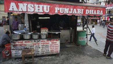 Small street restaurant in India with various pots and passers-by, Manali, Himachal Pradesh, India
