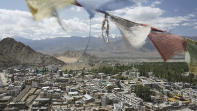 Colorful prayer flags over Leh, view from Leh Palace with mountain landscape in the background,
