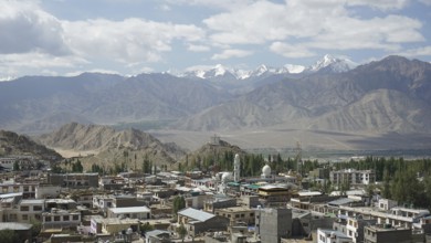 City panorama of Leh with snow-capped mountains in the background and blue sky, Ladakh, North