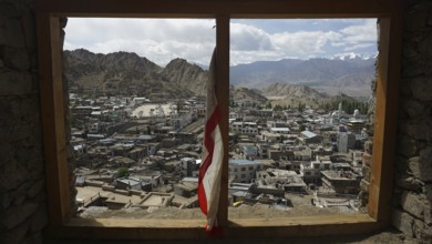 View through a window of Leh Palace over Leh in mountainous landscape with cloudy sky, Ladakh,